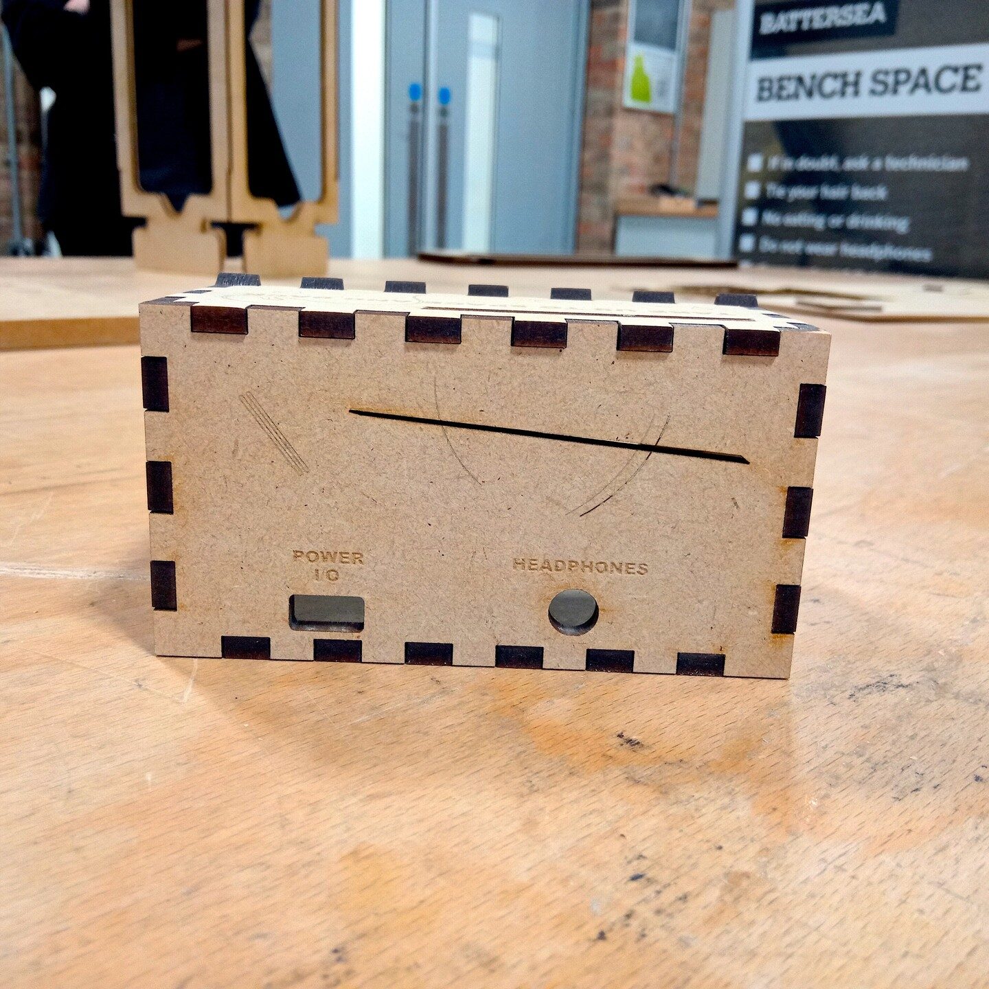 Finger-jointed MDF enclosure with engraved Power I/O and Headphones ports on an RCA workshop bench