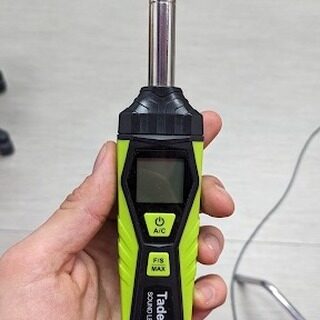 Hand holding a handheld sound-level meter