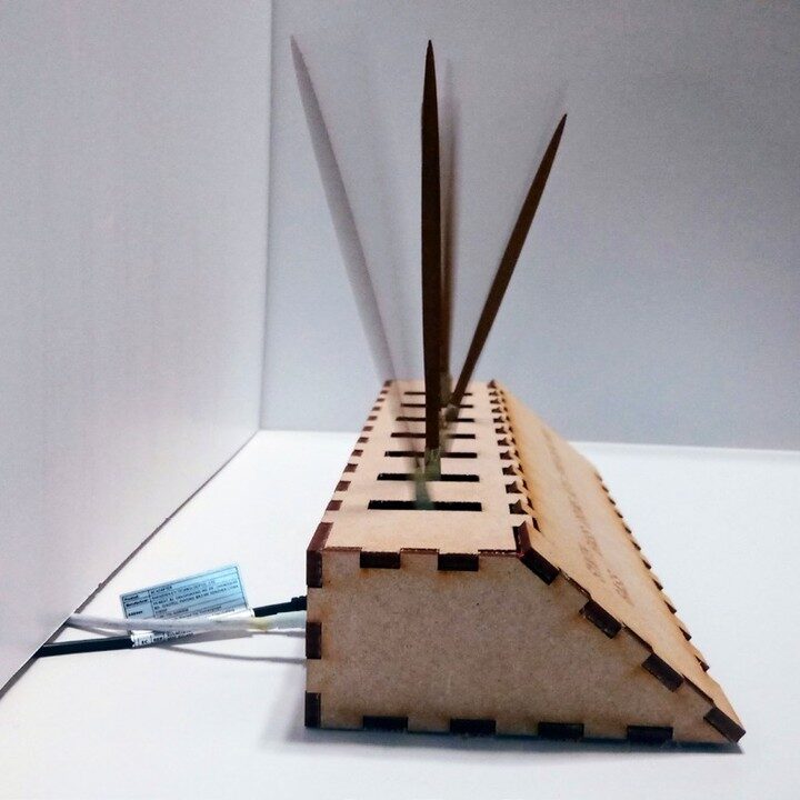 Square side view of the MDF wedge prototype with three tickers and trailing cables